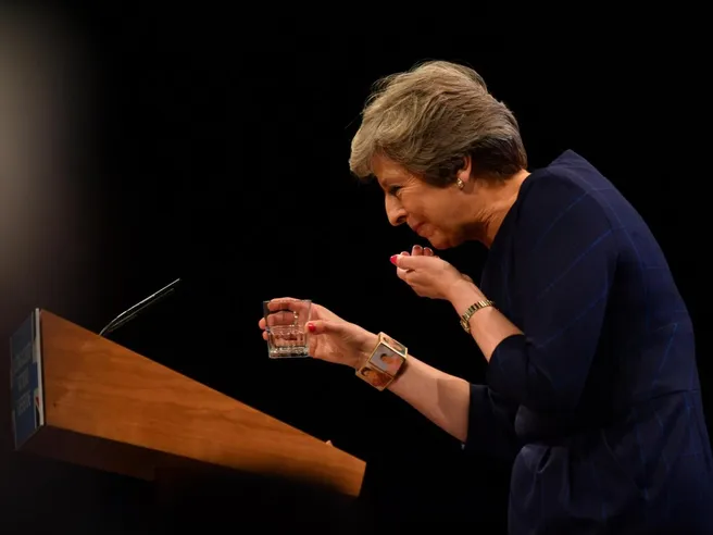 Discorso May un disastro, tra colpi di tosse e incursione comico. Tory la vogliono fuori, sterlina a minimo un mese